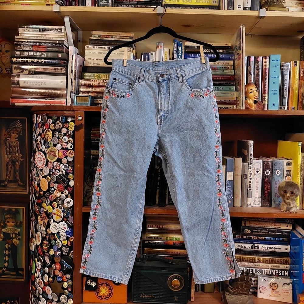 Vintage light wash denim with floral details and slits at the ankles.